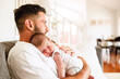 © Austockphoto - Newborn baby boy sleeping on fathers chest