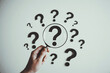 © MdAbulBasar - Hand pointing to a large question mark surrounded by smaller question marks