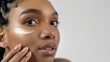 © Dao - Beauty and skin care. Skincare hydration and oil balance. Portrait of African American woman with afro braids hairstyle is applying a cream smear on her face and standing against white background