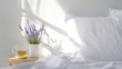 © KateMur - Soft minimalistic bedroom with white linen, lavender flowers, and a cup of chamomile tea on a wooden bedside table, cozy light, wellness atmosphere