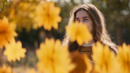 Wall Mural - Young woman reading book among autumn leaves with warm golden lighting. Perfect for educational content and seasonal lifestyle campaigns.