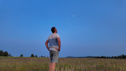 Wall Mural - amateur astronomer watching stars, moon, planets and other celestial objects from a field in nature.