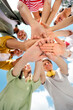 © deagreez - Group of young friends uniting hands outdoors on a sunny day symbolizing friendship, teamwork, and joy
