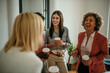 © La Famiglia - Businesswomen enjoying coffee break, laughing and talking in office