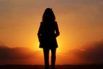 Wall Mural - hope. silhouette of woman under beautiful sky at sunset, double exposure