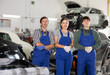 © JackF - Portrait of team of auto mechanics near cars in a car service center