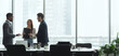 © Prostock-studio - Businesspeople talking in office, standing against window by table, panorama, copy space