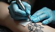 © junet - Artistic tattooing process in action, precise hand movements.