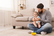 © Prostock-studio - Father takes care of his little son, feeding baby with porridge at home, copy space