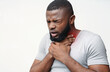 © Prostock-studio - Unhealthy african man touching neck and coughing with closed eyes over white background, copy space