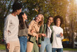 © Prostock-studio - International group of cheerful teenagers laughing while walking by golden park