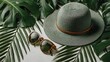 © Jojo* - Green straw hat and sunglasses on tropical leaves.