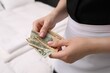 © New Africa - Chambermaid with tips indoors, closeup. Gratuity for work