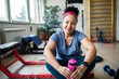© Marko Geber - Active senior woman resting after gym workout with water bottle