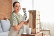 © Pixel-Shot - Young woman with brush painting wooden box at home