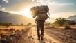 © abror - A hiker carrying a heavy pack on a dirt road at sunset