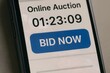 © Creative mind - Online auction bidding platform on mobile phone with bid now button and countdown timer display