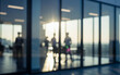 © Renderis - Blurred figures stand in a modern office with large windows and bright light.