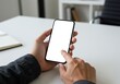© Hani Nuang - businessman using mobile phone with blank white screen mockup. hand holding a mobile phone with cell phone blank white screen mockup on desk at office.