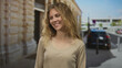 © Krakenimages.com - Woman hair flows as smiling face brightens street scene where blonde young subject poses in outdoor urban setting styled with casual natural tones.