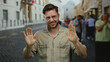 © Krakenimages.com - Young bearded man in casual shirt smiling on city street with cobblestone road in the background, capturing a lively outdoor urban scene during daytime