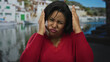 © Krakenimages.com - Woman making funny faces and covering her face at seaside, showcasing joyful and playful expressions against coastal backdrop.
