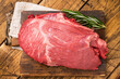 © Mironov - Fresh Raw Round Silverside beef meat cut, inside round with hrebs for roasting. wooden background. Top view