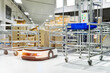 © funfunphoto - Automatic warehouse robot car carries cardboard box assembly in factory.