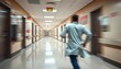 © Somnuek - Blurred motion of a doctor rushing down a hospital corridor towards an emergency room, urgent, injury