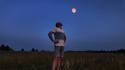 Wall Mural - amateur astronomer watching stars, moon, planets and other celestial objects from a field in nature.