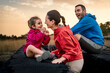 © Lomb - A mother and daughter share a joyful, laughing moment of connection outdoors at sunset. A happy family enjoying a tender moment of bonding and love during a hiking adventure.