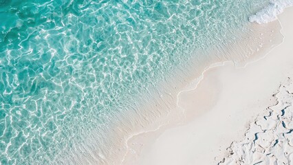  Aerial view of a white sandy beach meeting clear turquoise water with gentle waves creating natural patterns on the shoreline.