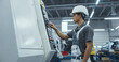 © Gorodenkoff - Portrait of a Young Asian Male Technician in a White Hard Hat Setting Up an Automated CNC Milling Machine in an Advanced Manufacturing Plant. Metal Industry Specialist Performing Tasks at Work