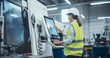 © Gorodenkoff - Female Machinery Technician Using Laptop Computer and Programming a CNC Machine at an Advanced Metal Production Facility. Young Woman in Work Gear Setting Up Manufacturing Process in a Factory