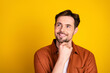 © deagreez - Casual young man with a charming smile and thought-provoking facial expression against a vibrant yellow background