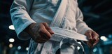 Young jiu-jitsu athlete tying their white belt