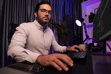 Working smart IT developer analyzing data software development on two pc screen, creating application program updated version online website page system online at neon light cyber office. Surmise.