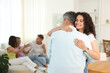 © New Africa - Happy friends hugging at home, selective focus