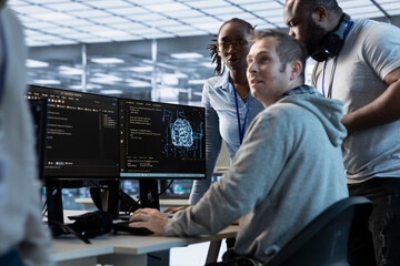 engineer helped by colleagues to find errors in code while doing checkup on server room used for ai 