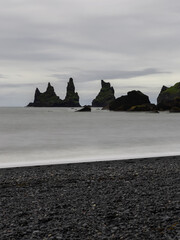 Wall Mural - Overcast day view over Reynisdrangar rock formation, Iceland.