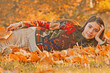 © Volodymyr - Autumn woman posing in golden sunlight. Stylish girl with fall leaves. Romantic portrait with autumn foliage. Model in autumn nature. Woman with falling leaves. Girl outdoor shoot in autumn park.