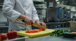 © Sayyaf - Chef in a professional kitchen, meticulously slicing vegetables for a culinary dish.
