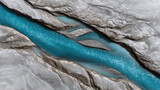 Aerial view of braided glacier river with turquoise pools and textured patterns
