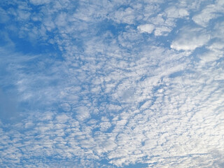 Wall Mural - A stunning background of a clear blue sky with delicate white cloud formations on a bright sunny day. Peaceful and serene atmosphere, suitable for themes related to nature, weather, relaxation, travel
