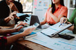 © Dino - Brainstorming of young modern group. Team meeting to achieve goal. Business people discussing finance business and analysis. Teamwork concept in modern office. Calculating personal tax for client.