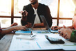 © Dino - Brainstorming of young modern group. Team meeting to achieve goal. Business people discussing finance business and analysis. Teamwork concept in modern office. Calculating personal tax for client.