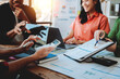 © Dino - Brainstorming of young modern group. Team meeting to achieve goal. Business people discussing finance business and analysis. Teamwork concept in modern office. Calculating personal tax for client.
