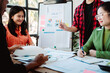 © Dino - Brainstorming of young modern group. Team meeting to achieve goal. Business people discussing finance business and analysis. Teamwork concept in modern office. Calculating personal tax for client.