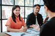 © Dino - Brainstorming of young modern group. Team meeting to achieve goal. Business people discussing finance business and analysis. Teamwork concept in modern office. Calculating personal tax for client.