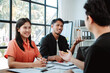 © Dino - Brainstorming of young modern group. Team meeting to achieve goal. Business people discussing finance business and analysis. Teamwork concept in modern office. Calculating personal tax for client.